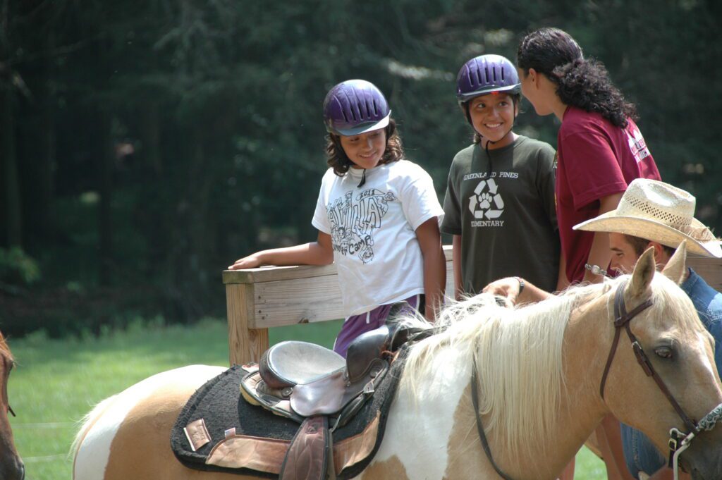 A group of friends enjoying a horseback riding activity in a park